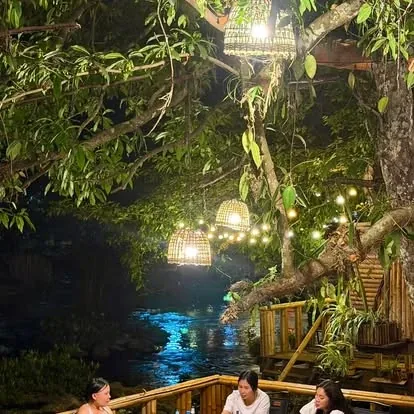 ມຸມນັ່ງກິນເຂົ້າແຄມຫ້ວຍຕອນຄໍ່າ ໂຄມຫວາຍເທິງຕົ້ນໄມ້
