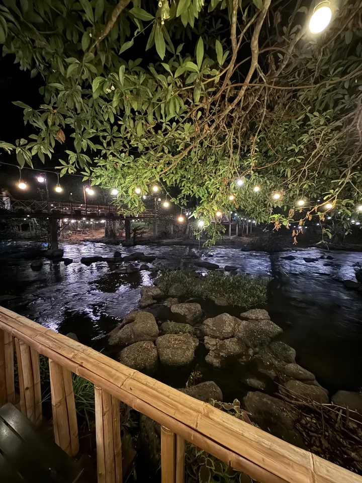 ຫ້ວຍຕອນກາງຄືນ ແສງໄຟສະທ້ອນຜິວນ້ຳ ເບິ່ງຈາກລະບຽງໄມ້ໄຜ່